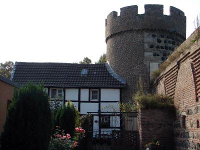 Fachwerkhaus an Burgturm geschmiegt