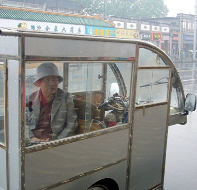 Passagier in einer motorisierten Rikscha in Peking