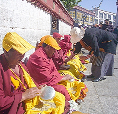 Tibetische  Mönche in Lhasa  beim Kornmahlen