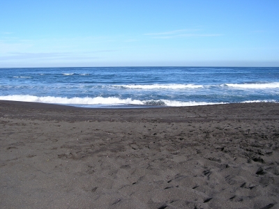 schwarzer Strand, blaues Meer