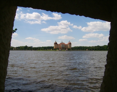 Blick durch Sandsteinfenster auf Schloss Moritzburg