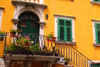 gelbe Fassade mit Treppe und Blumen