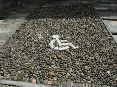 Parkplatzzeichen im Boden aus Kiesel und Marmor nur für Rollstuhlfahrer