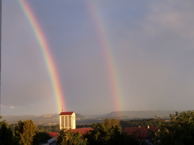Doppel-Regenbogen über Kirchturm