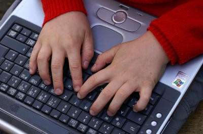 Kinderhände auf Laptoptastatur