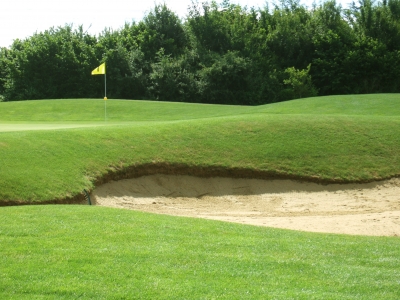 Golfplatz mit Sandbunker und Fahne