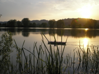 Modellschiff im Baggersee beim Sonnenuntergang