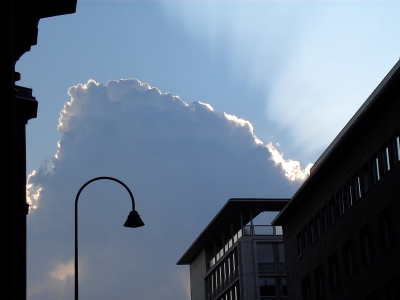 Quellwolke über Köln mit Sonne im Hintergrund