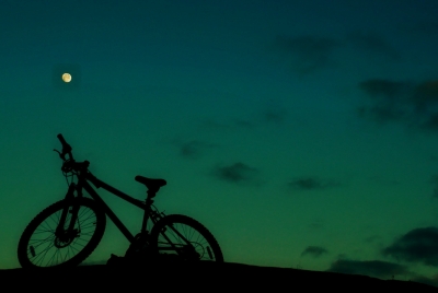 Silhouette eines Fahrrades bei Nacht (türkisfarbener Hintergrund)