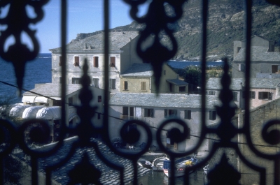 Hafenszene mit schmiedeeisernem Gitter davor auf Korsika