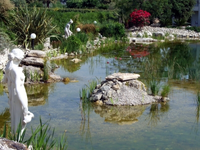 Teich-Idyll mit Steinen und mit Figuren am Rand