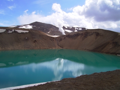 grüner Kratersee mit Schneefeld und Dampfsäule (Island)
