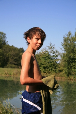 Junge am Badesee mit Handtuch