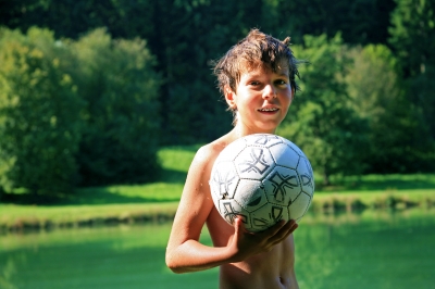 Junge am Badesee mit Ball