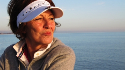 Seniorin mit Blick aufs abendliche Meer