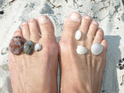 Füße mit Muscheln und Steinen