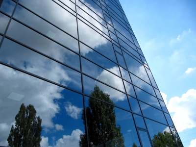 Glasfassade mit Wolkenspiegelung
