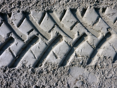 Reifenspuren eines Traktors im Sand