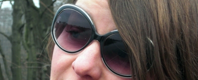 Frau schaut durch Sonnenbrille