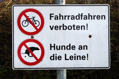 Fahrradfahren verboten! Hunde an die Leine!