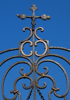 Das alte Kreuz am eisernen Friedhofstor
