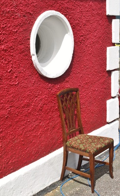 Stuhl vor roter Hausfassade