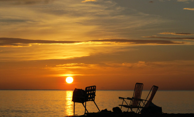 Liegestühle am Strand im Sonnenuntergang