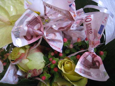 Geldscheine mit Rosen und einer Anthurie