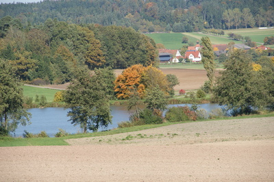 Dorf mit Weiher im Herbst 1
