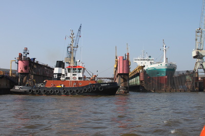 im Hamburger Hafen: Schlepper und ein Schiff im Dock
