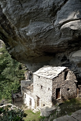 verlassenes Bergdorf unter einem Felsen