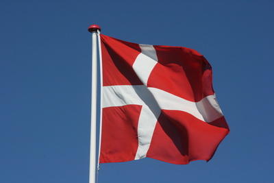 Dänische Flagge vor blauem Hintergrund