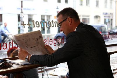 Mann im Cafe mit Zeitung