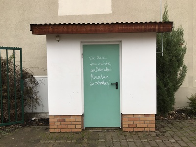 Tür mit Spruch: "Die Oberen tun nichts, außer den Menschen zu schaden" Tür mit Spruch: "Die Oberen tun nichts, außer den Menschen zu schaden"