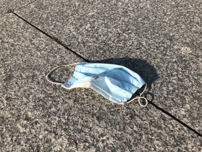 Gebrauchte Gesichtsmaske auf dem Boden Gebrauchte Gesichtsmaske auf dem Boden