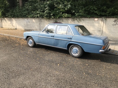 Blauer Oldtimer vor grauer Wand Blauer Oldtimer vor grauer Wand