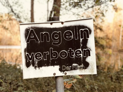Schild: Angeln verboten. Der Fisch. Schild: Angeln verboten. Der Fisch.