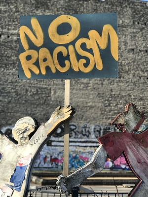 Holzfiguren mit Schild mit Schriftzug "No Racism" / Foto: Alexander Hauk