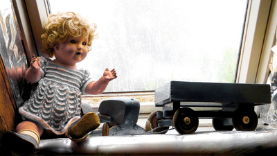Spielende Puppe am Dachboden Fenster....
