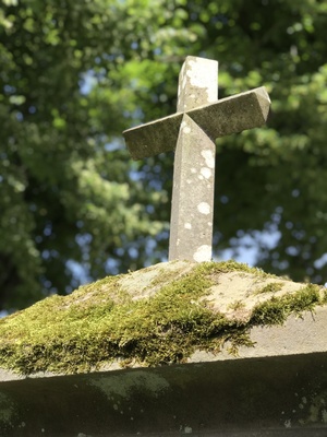 Kreuz auf altem Grabstein mit Moos Kreuz auf altem Grabstein mit Moos