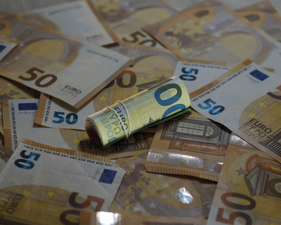 gerollter 100-Euro-Schein auf verschiedenen anderen Banknoten
