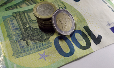 Euro-Münzen auf mehreren 100-Euro-Scheinen, Nahaufnahme
