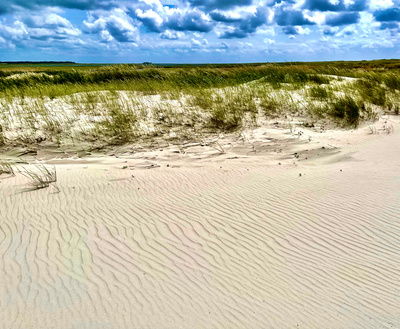 Dünen und Sand vor Wolkenhimmel