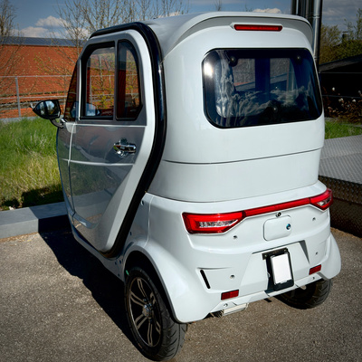 Wei&szlig;er e-Kabinenroller EV 3.1 von hinten auf Parkplatz